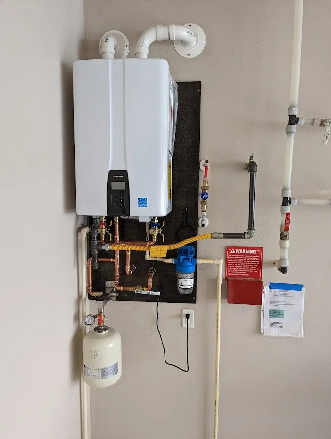 Professional plumber installing copper piping in a Emerson home